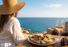 Woman at the seaside with a plate of mediterranean food in front of her