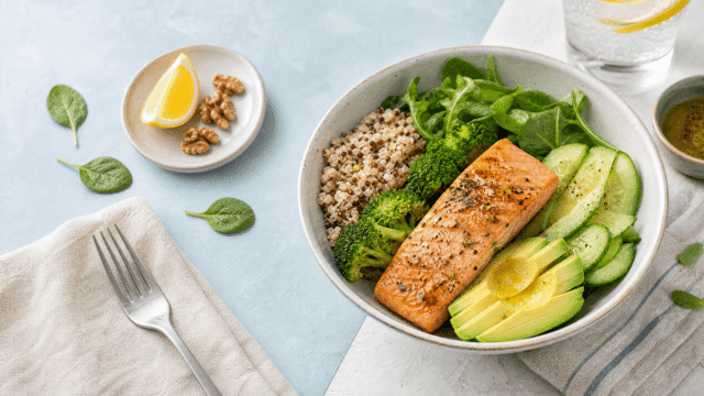 A balanced GLP-1-friendly lunch bowl with salmon, quinoa, broccoli, greens, cucumber, and avocado